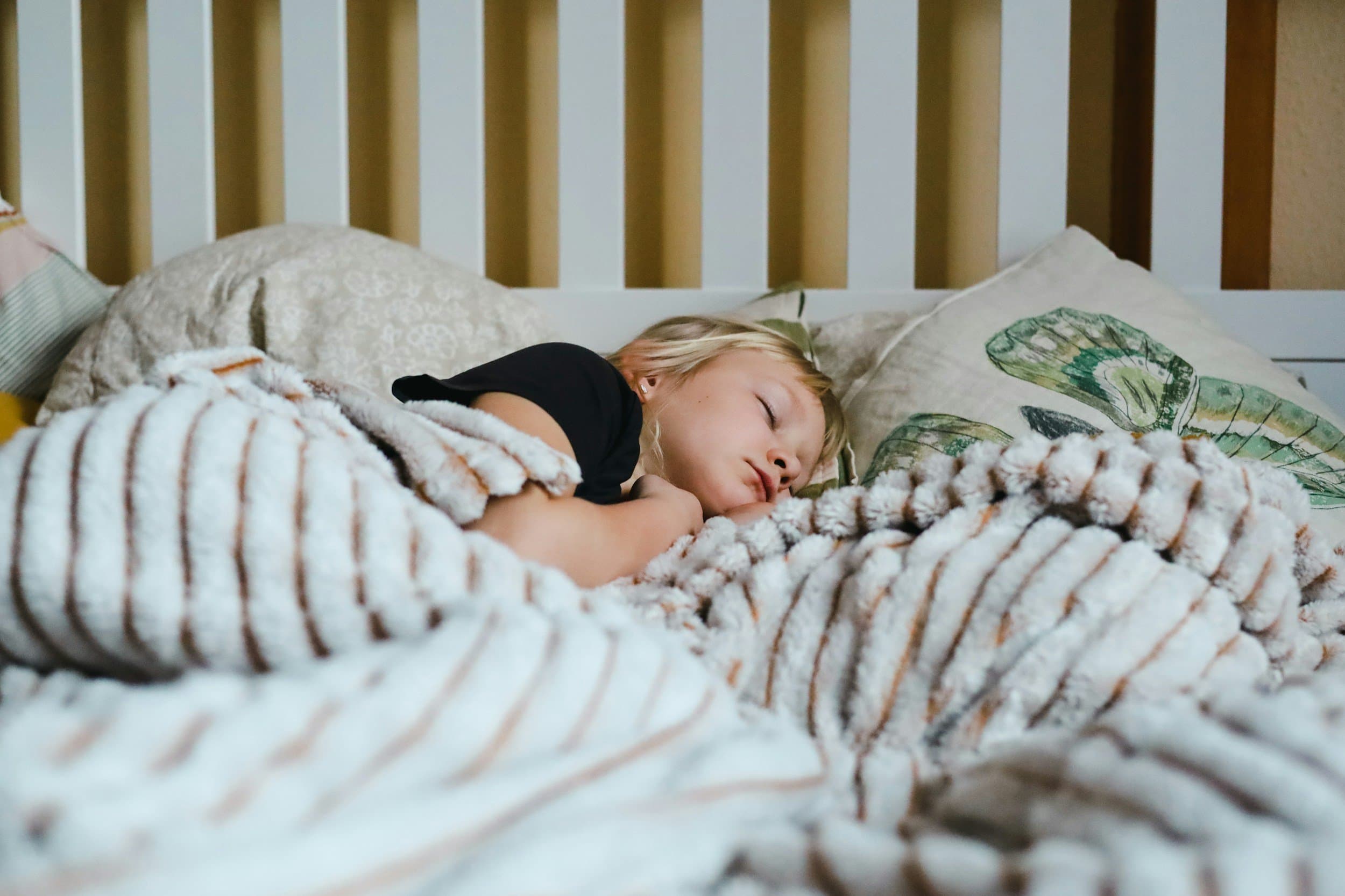 A young child asleep on their side in a cot with the lips slightly parted, reflecting the night-time breathing worth noting in children, at Align Dental Surgery