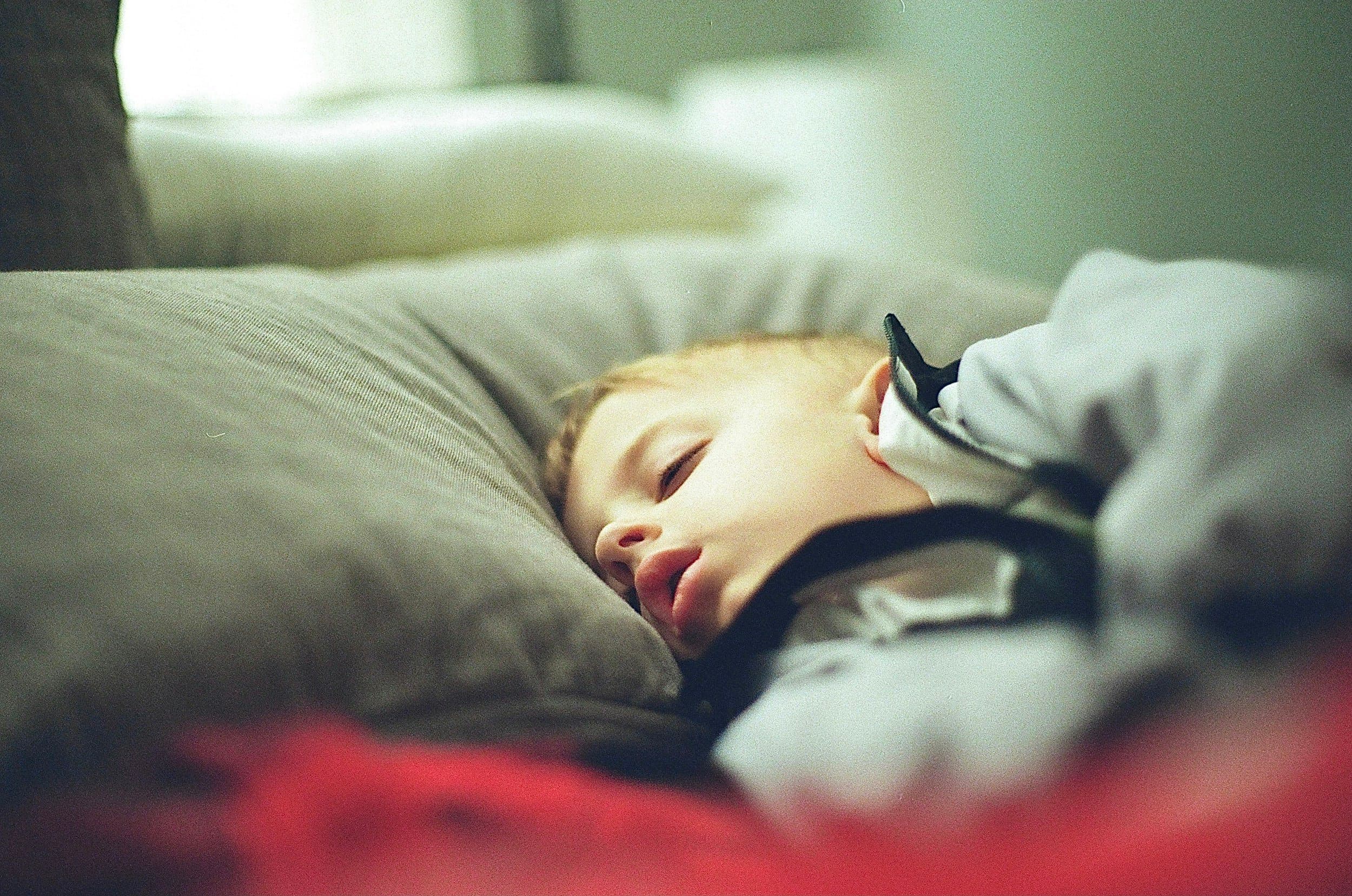 A black and white portrait of a young boy resting his chin on his hand, at Align Dental Surgery