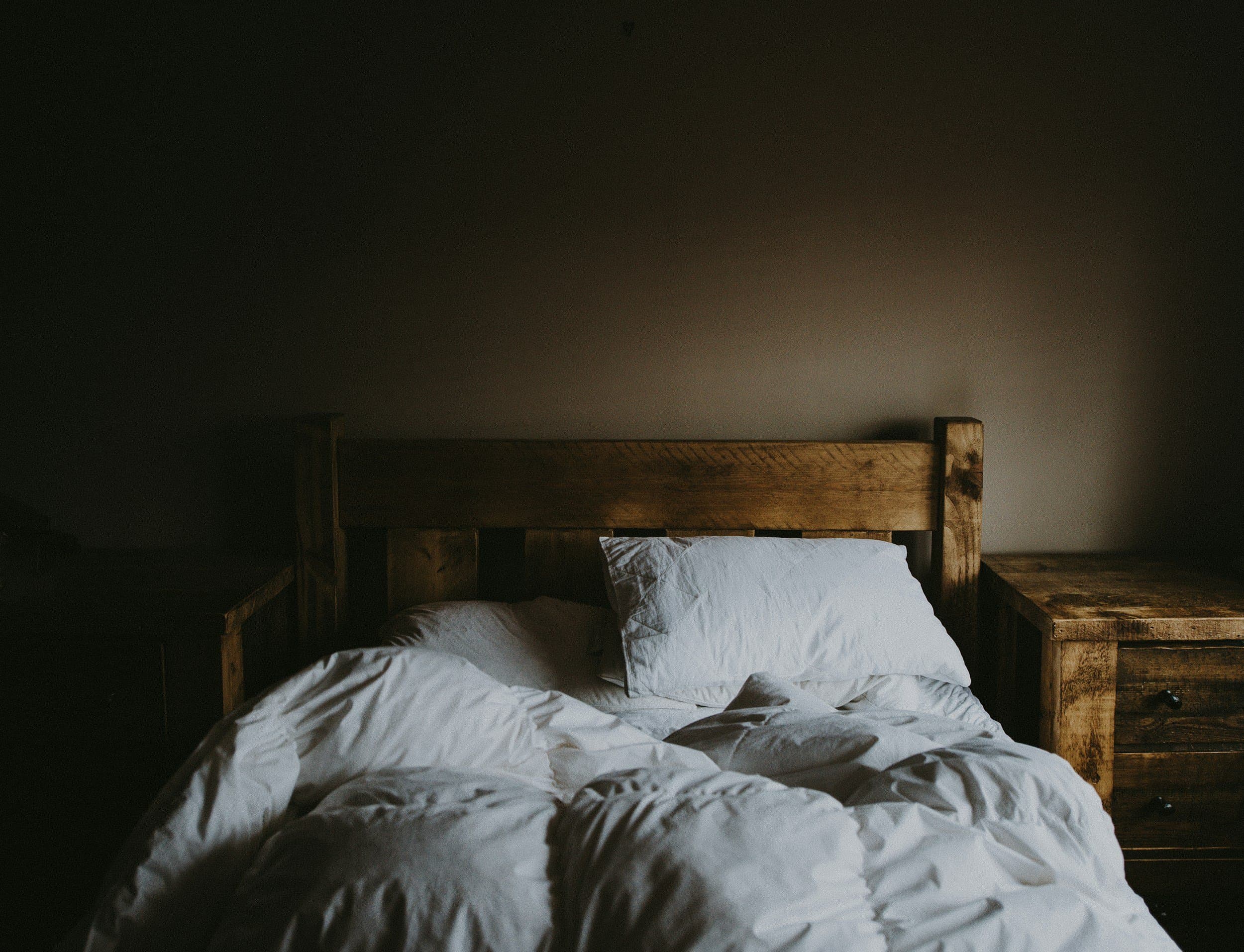 An empty unmade bed in a dimly lit bedroom, reflecting the disturbed sleep linked to mouth breathing, at Align Dental Surgery